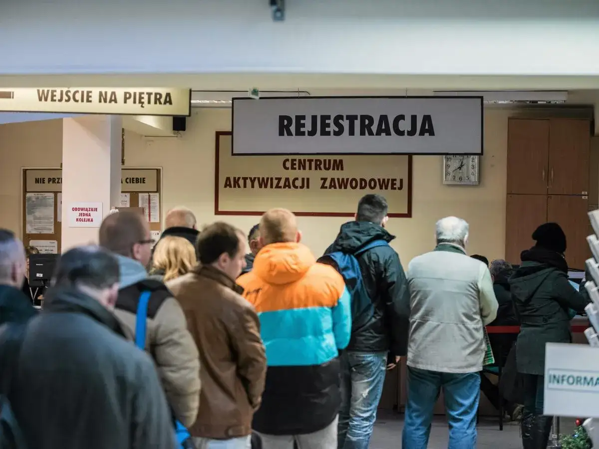 Ludzie stoją w kolejce do rejestracji w centrum aktywizacji zawodowej. Obrazek ten może symbolizować stopę bezrobocia w Polsce.