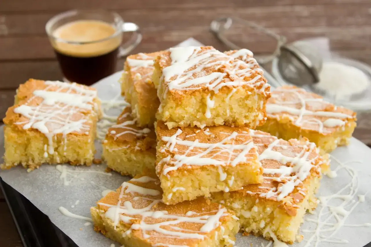 Nybakade bitar av en saftig kaka, perfekt f&ouml;r att baka i l&aring;ngpanna. Garnerad med vit choklad och serverad med en kopp kaffe.