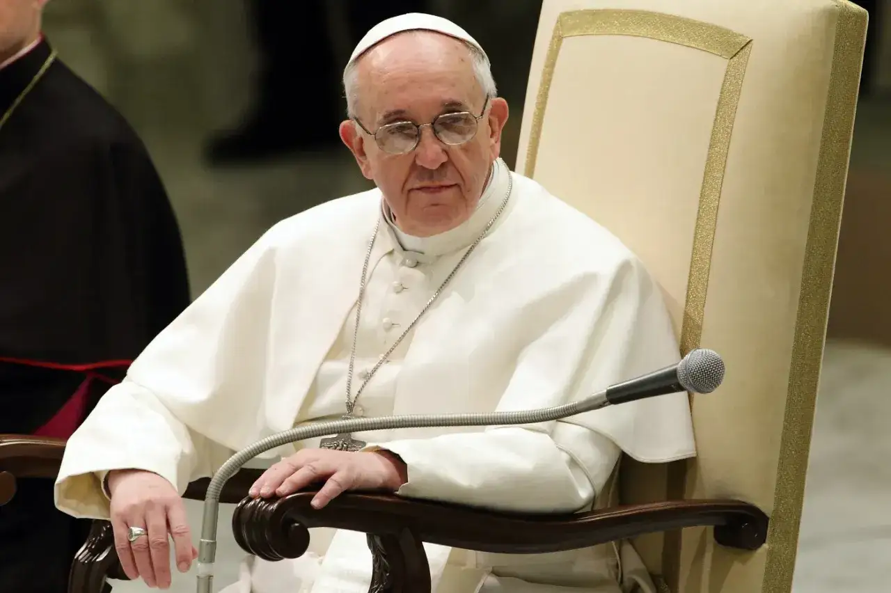 Papież Franciszek siedzi, rozważając przyczyny trudności z akceptacją dogmatu o nieomylności papieża.