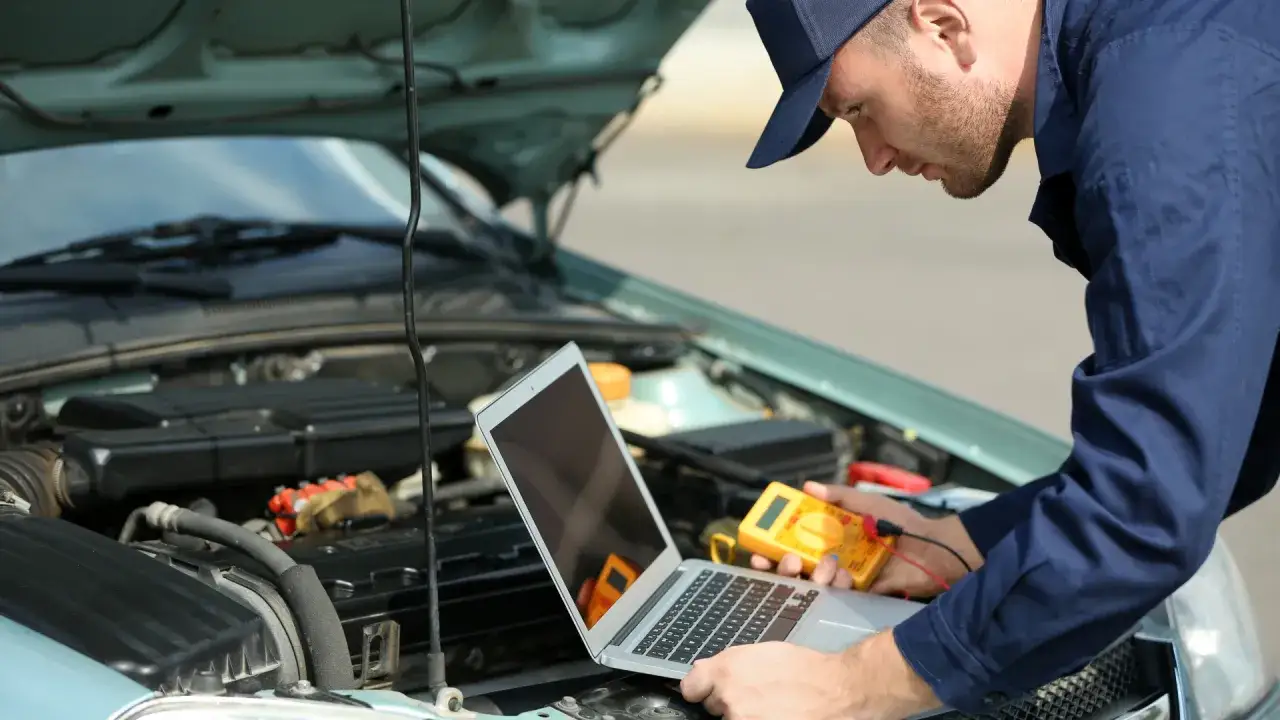 warsztat samochodowy specjalistyczny, mechanik przy komputerze diagnostycznym