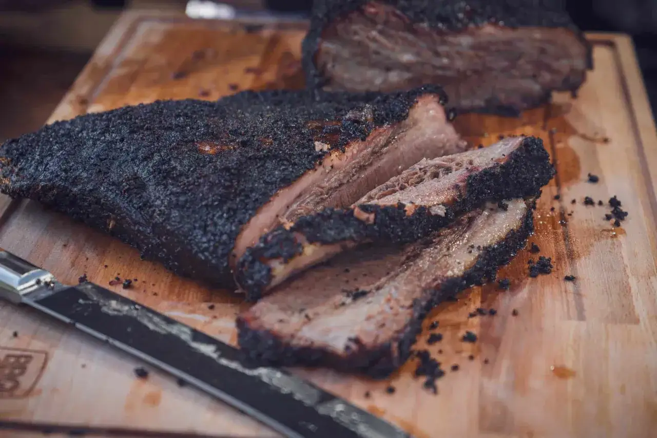 Saftiger Brisket Smoker auf einem Holzbrett, frisch aufgeschnitten.