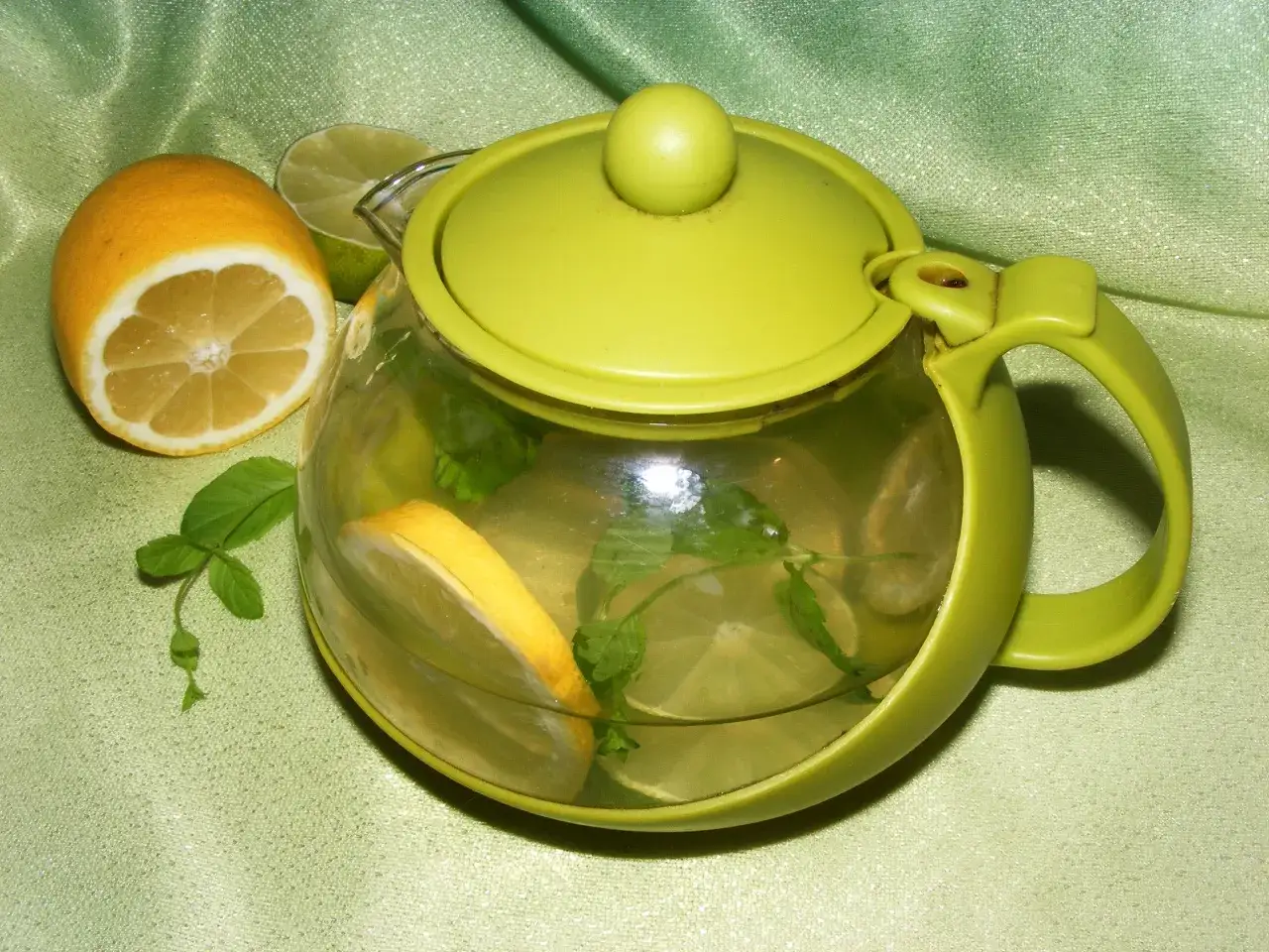 Zielona czajniczek z plasterkami cytryny i limonki, liśćmi mięty. Czy limonka jest zdrowa? Ten napój z pewnością tak!