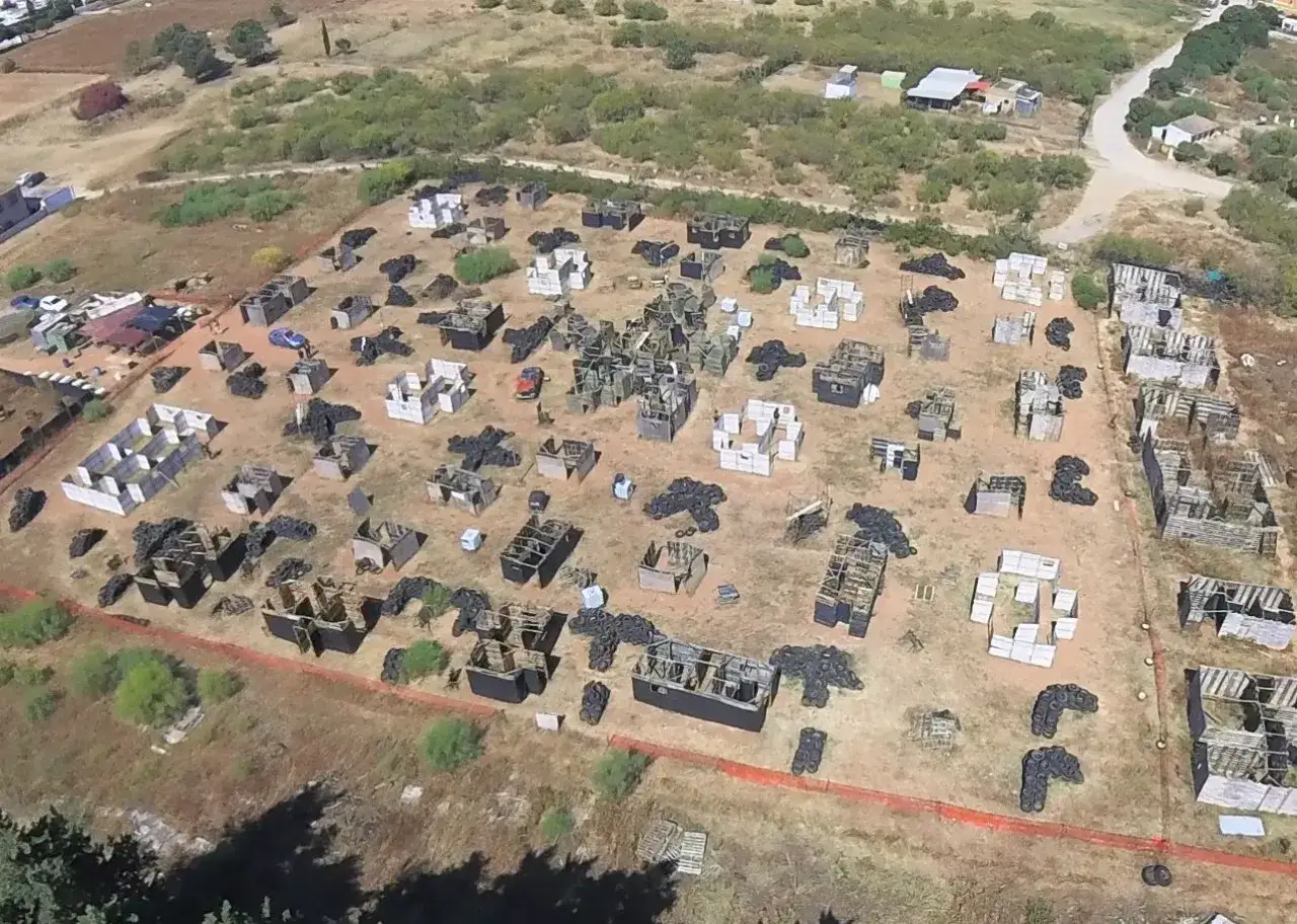 Campo de airsoft la Mancha con estructuras de madera y neumáticos, listo para la acción.