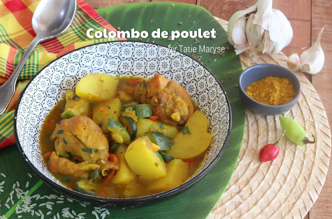 Un plat de poulet Colombo, riche en épices, avec des pommes de terre, des courgettes et des piments, servi dans un bol décoratif.