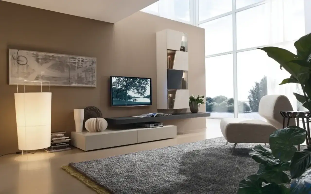 Soggiorno moderno con pareti color tortora, un divano beige, tappeto grigio e un'ampia vetrata. Ottime idee colori pareti per un ambiente rilassante.