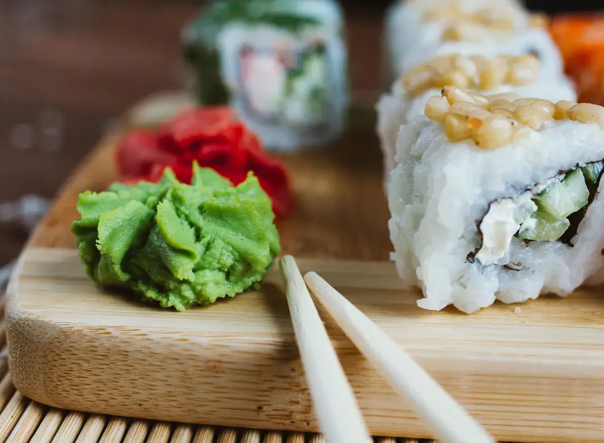 Zielone, ostre wasabi obok sushi i marynowanego imbiru. To jest wasabi, japoński chrzan o intensywnym smaku.