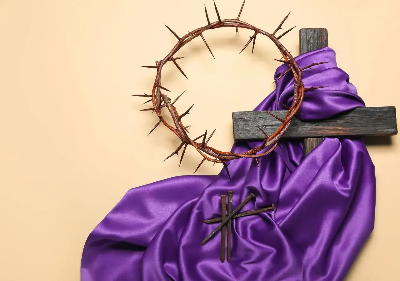 Korona cierniowa, krzyż i gwoździe na fioletowej tkaninie. Symbol Męki Pańskiej, krzyżu chrystusa tekst.