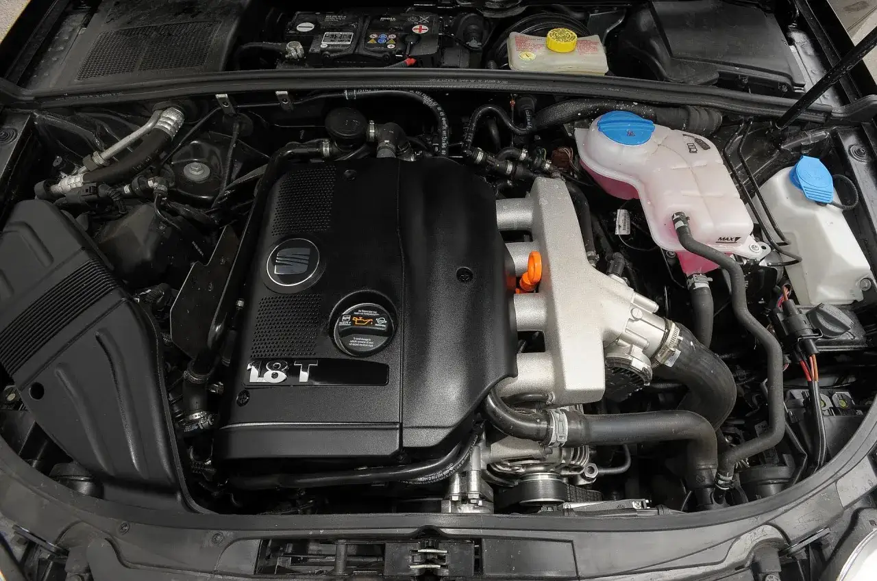 Silnik 1.8 T w Seat Exeo 2.0 TDI. Widoczny blok silnika, przewody i zbiorniczki płynów.
