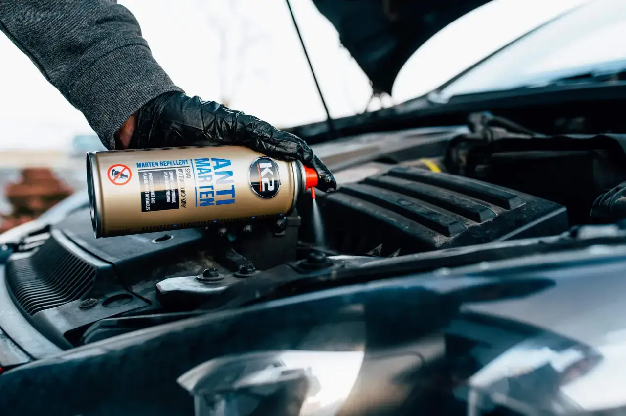 Ręka w czarnej rękawiczce aplikuje spray 