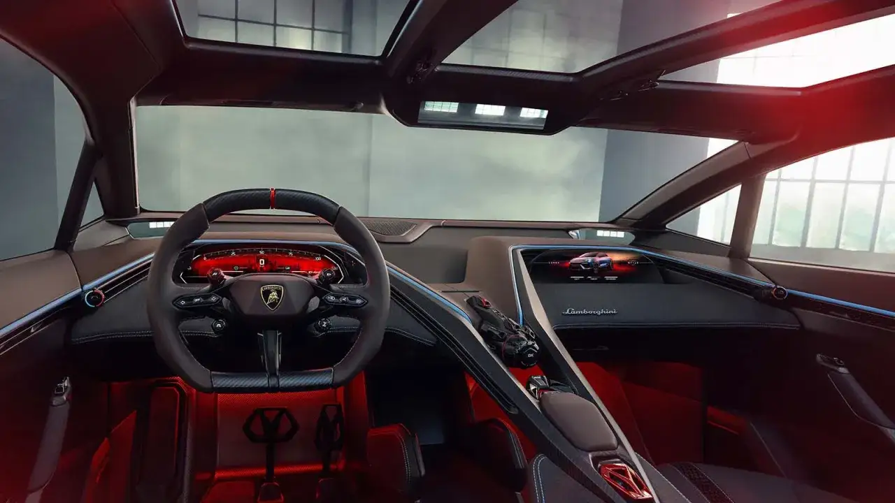 Wnętrze Lamborghini Lanzador: czerwone akcenty, cyfrowy kokpit i ekran z wizualizacją auta.
