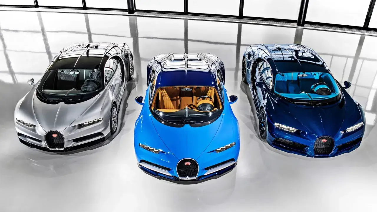 Trzy Bugatti Chiron w r&oacute;żnych kolorach: srebrnym, niebieskim i granatowym. Zastanawiasz się, ile kosztuje Bugatti Chiron?