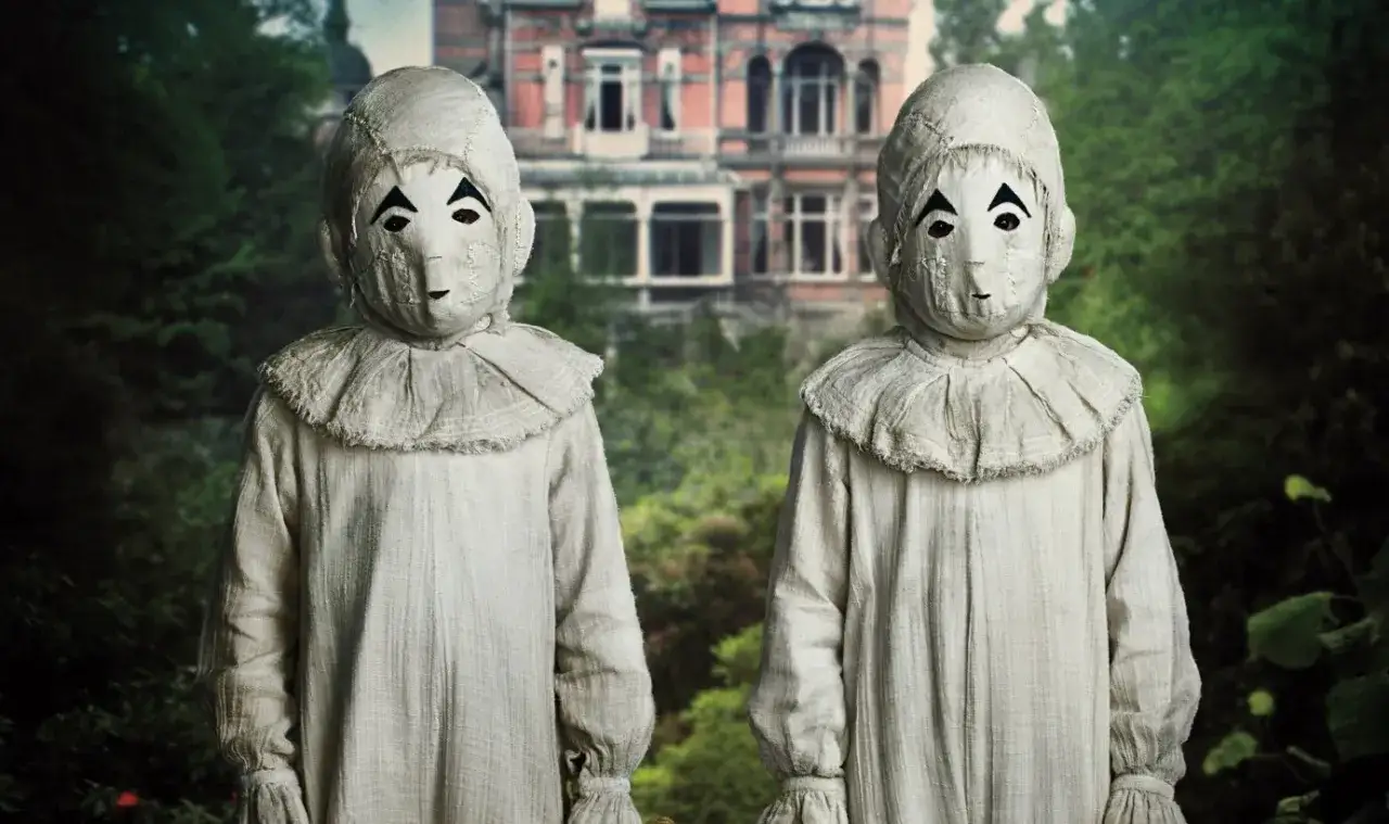 Dwie postacie w maskach przypominających laleczki, z filmu 