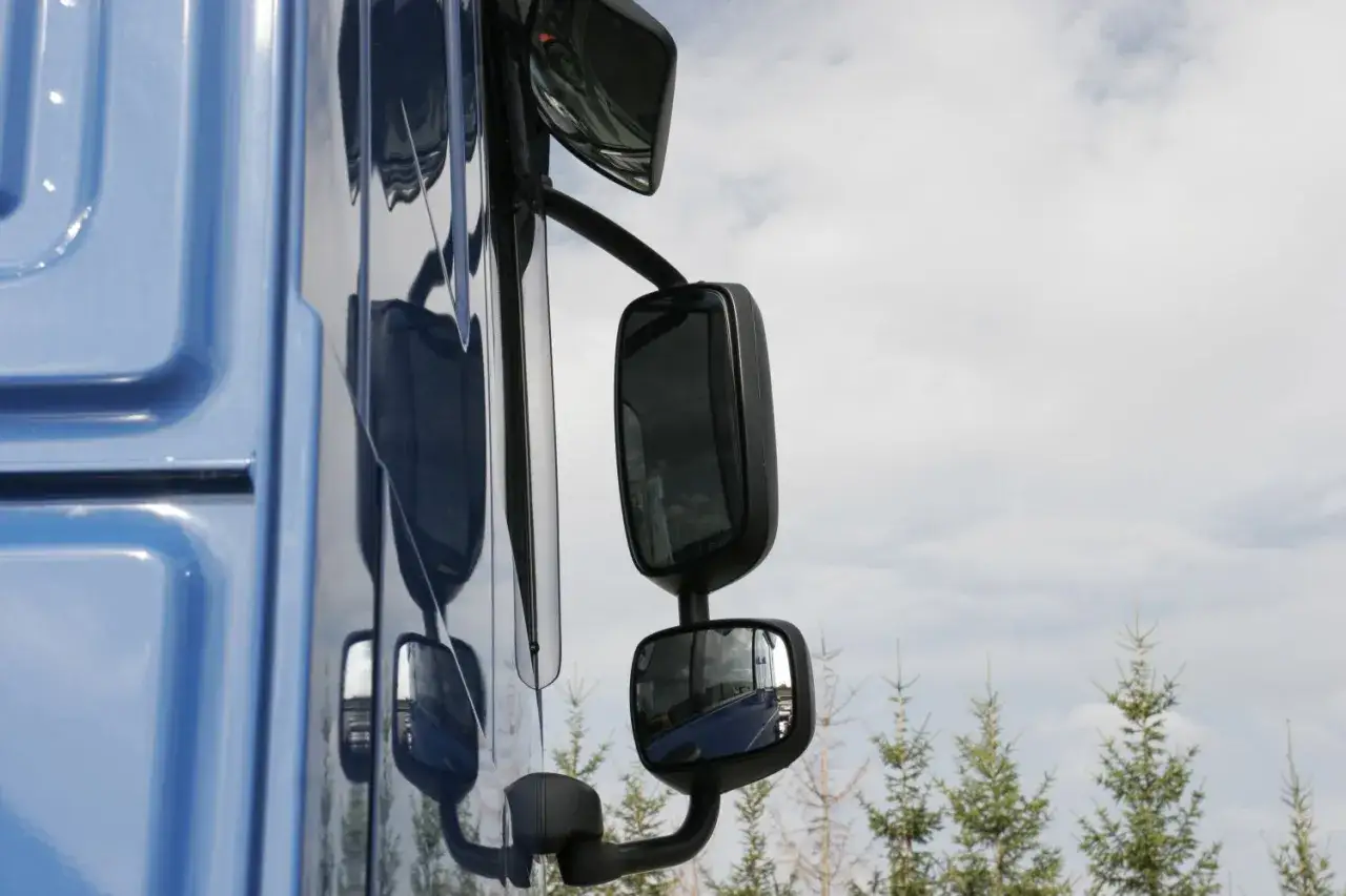 Vue rapproch&eacute;e du c&ocirc;t&eacute; bleu d'un tracteur, montrant les r&eacute;troviseurs. La largeur d'un tracteur est bien visible.