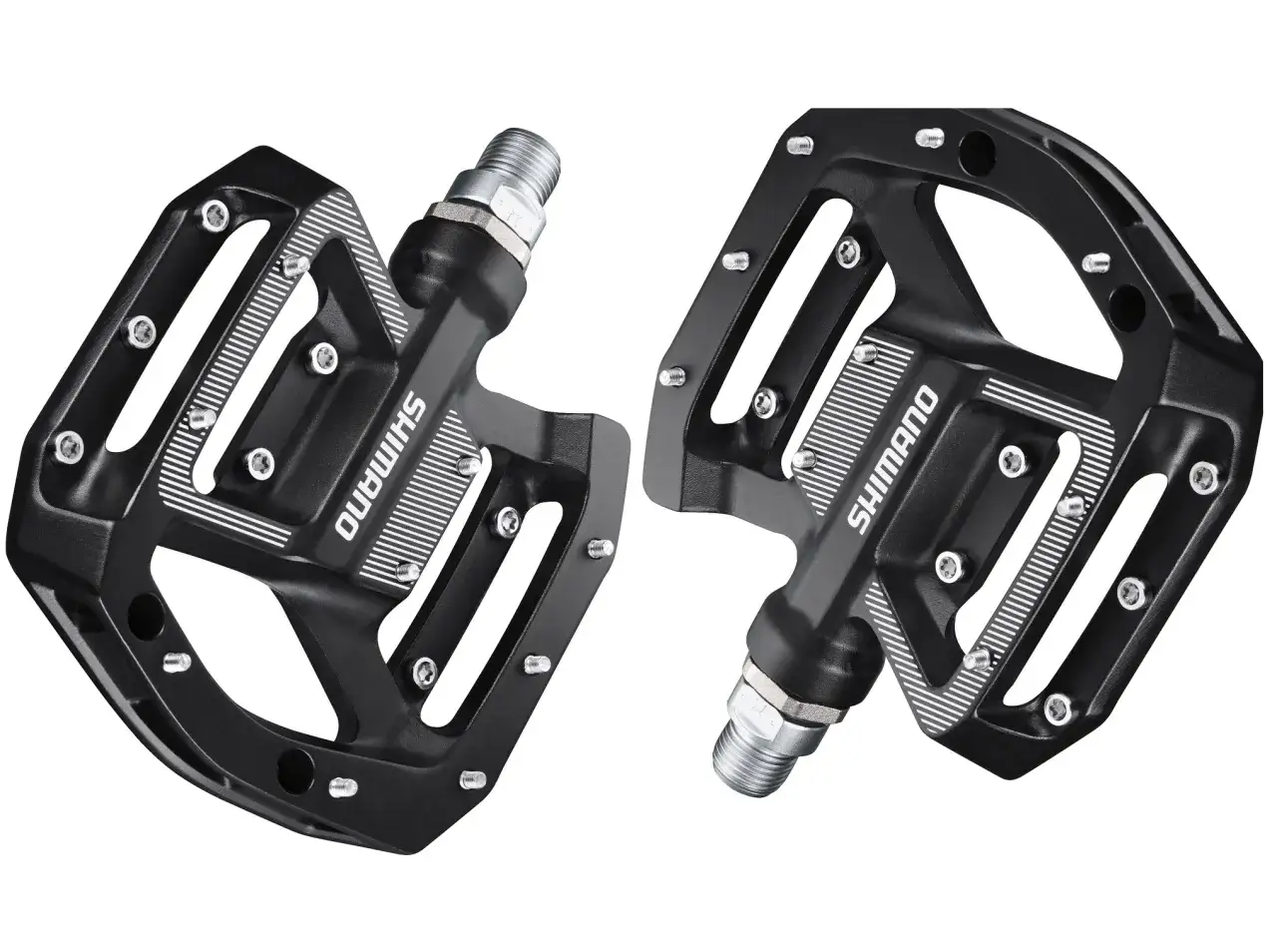 Dwa czarne pedały platformowe Shimano z metalowymi pinami i wycięciami, gotowe do montażu na rowerze.