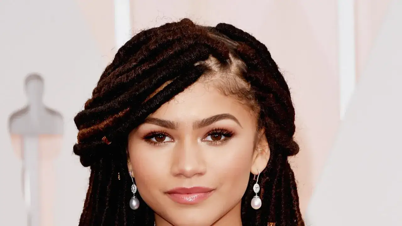Zendaya z imponującym afro loki, w eleganckich kolczykach z perłami.