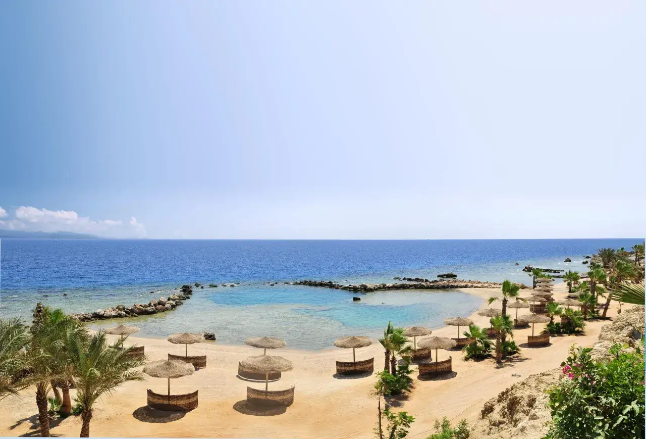 Piękna pogoda w Marsa Alam: piaszczysta plaża, palmy, turkusowe morze i słomiane parasole zapraszają do relaksu.