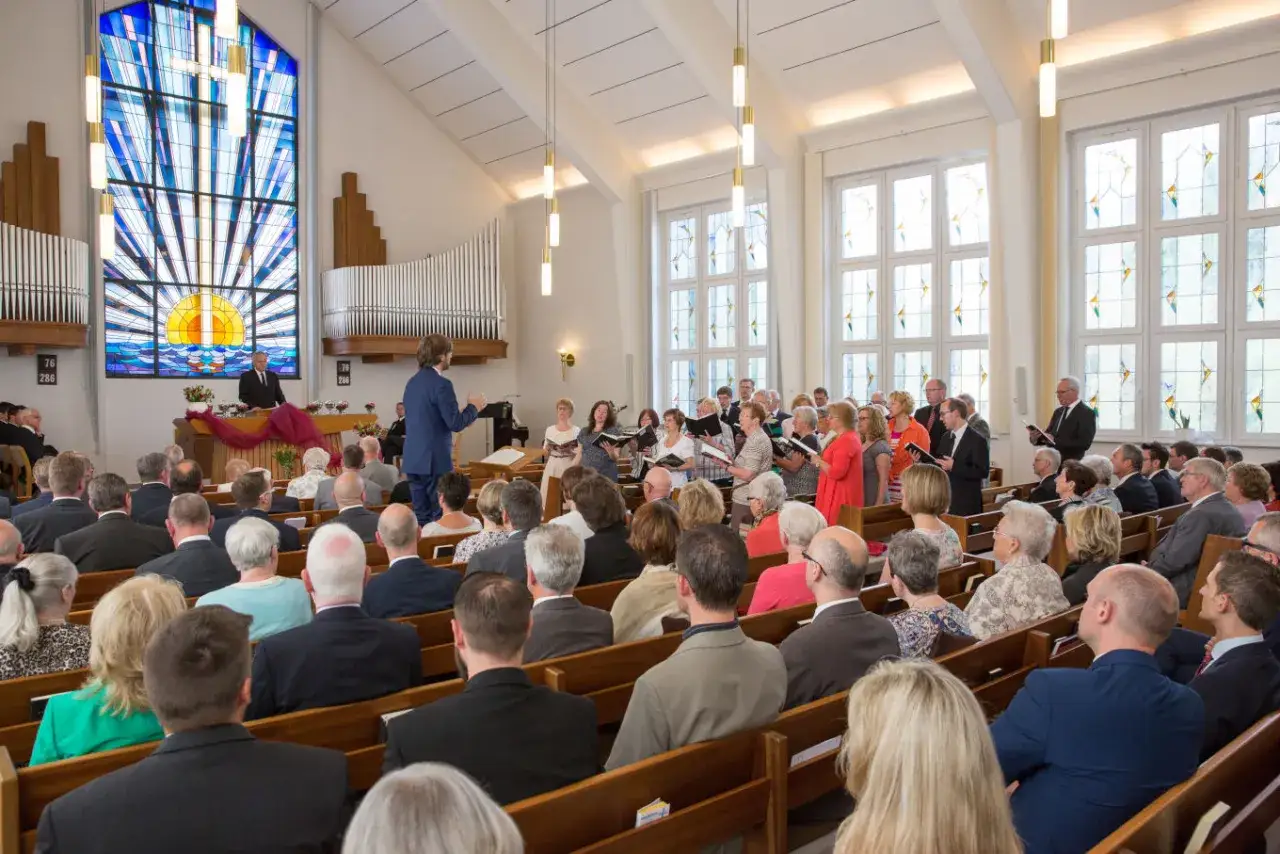 Gottesdienst in einer Kirche mit Chor und Gemeinde. Ob neuapostolische Kirche, Sekte oder nicht, die Atmosphäre ist friedlich.