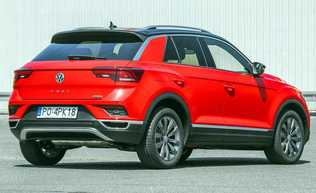 Czerwony Volkswagen T-Roc, idealny jako samochód dla kobiety. Stylowy, miejski SUV z czarnym dachem.
