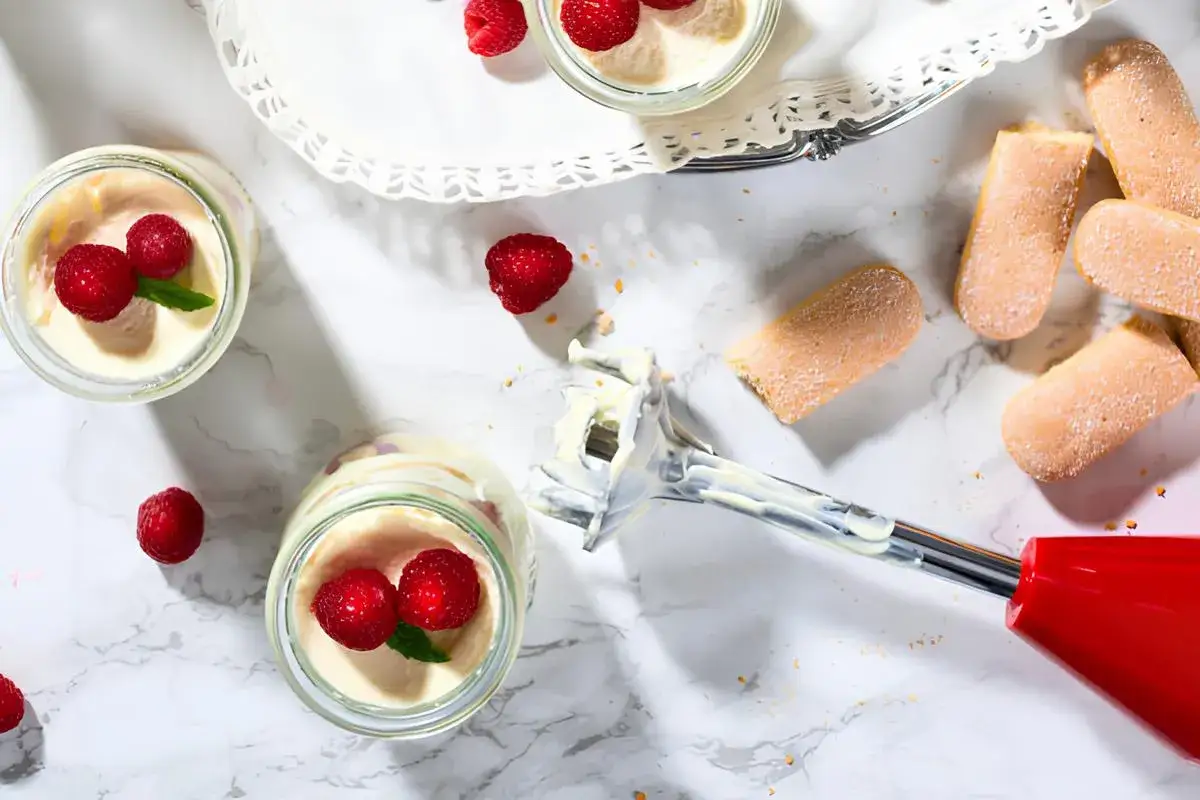 Des verrines de tiramisu aux framboises, garnies de chantilly maison, avec des biscuits &agrave; la cuill&egrave;re et un mixeur plongeant.