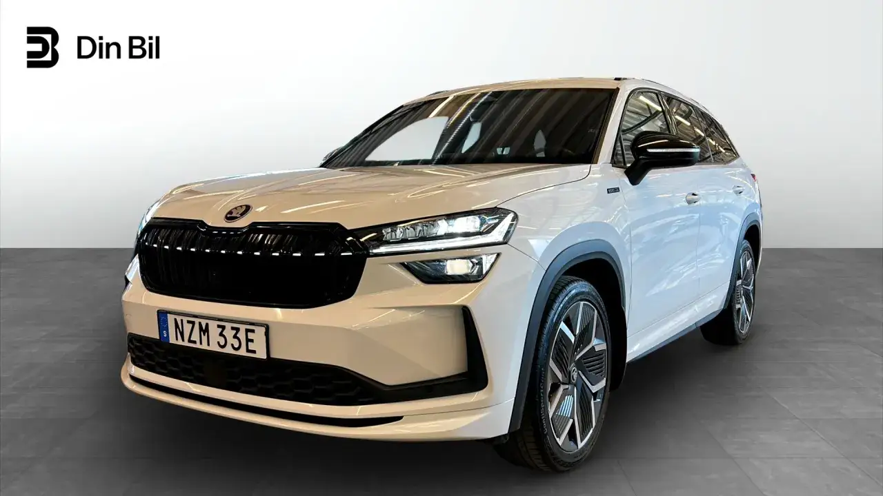 Vit Skoda Kodiaq i en bilhall, redo för ett skoda kodiaq test. Modern design med LED-strålkastare och snygga fälgar.