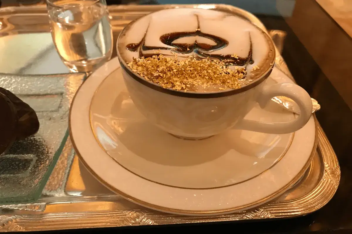Un cappuccino decorato con cioccolato e scaglie d'oro, un'esperienza che sa di miglior caffè al mondo.