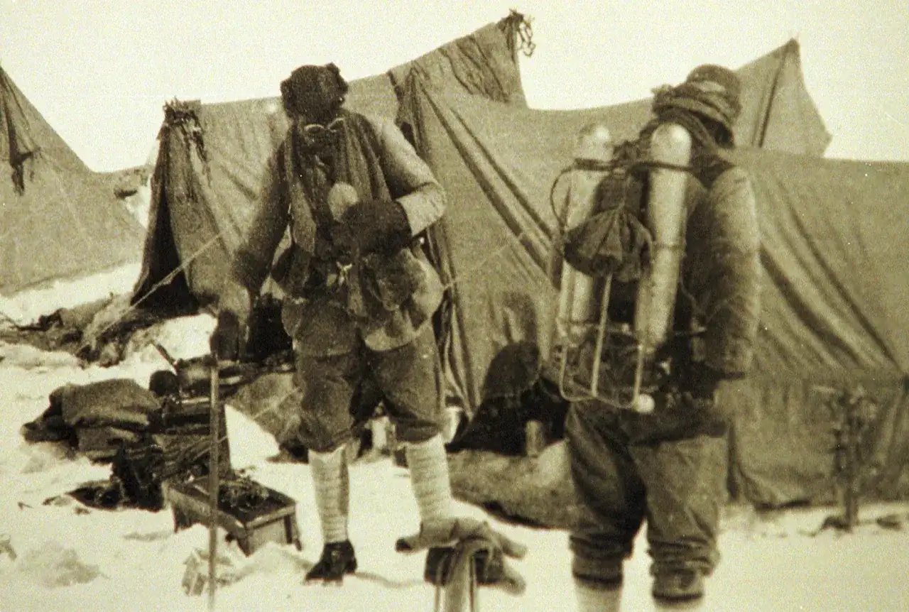 Expedici&oacute;n en la nieve. Mallory Irvine, con equipo de monta&ntilde;a, se prepara junto a tiendas de campa&ntilde;a.