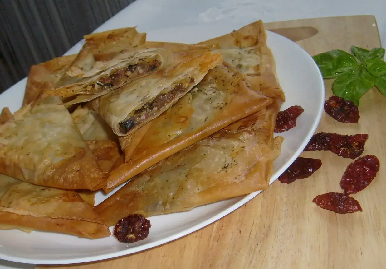 Pyszne trójkątne pierożki z ciasta filo, nadziewane farszem. Świetny przykład, co można zrobić z ciasta filo.