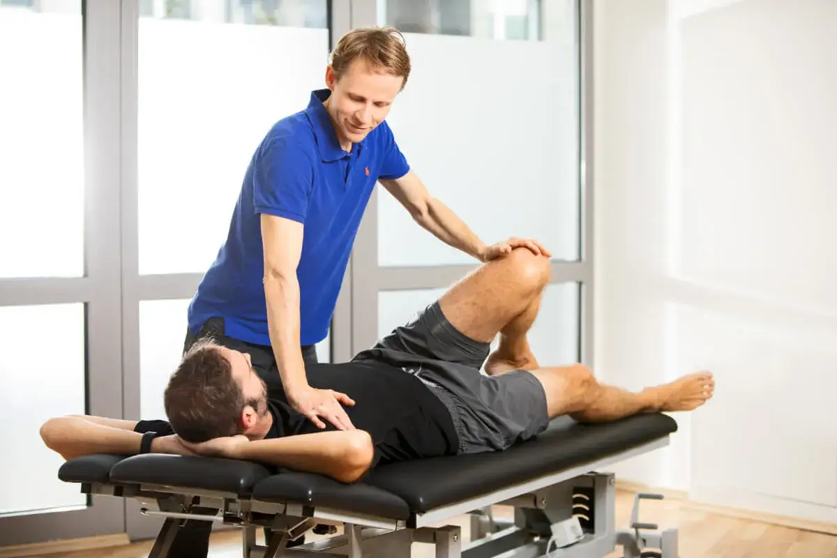 Ein Osteopath behandelt einen Mann auf einer Liege. Dies zeigt, was ist Osteopathie bei erwachsenen: sanfte manuelle Techniken zur Linderung von Beschwerden.