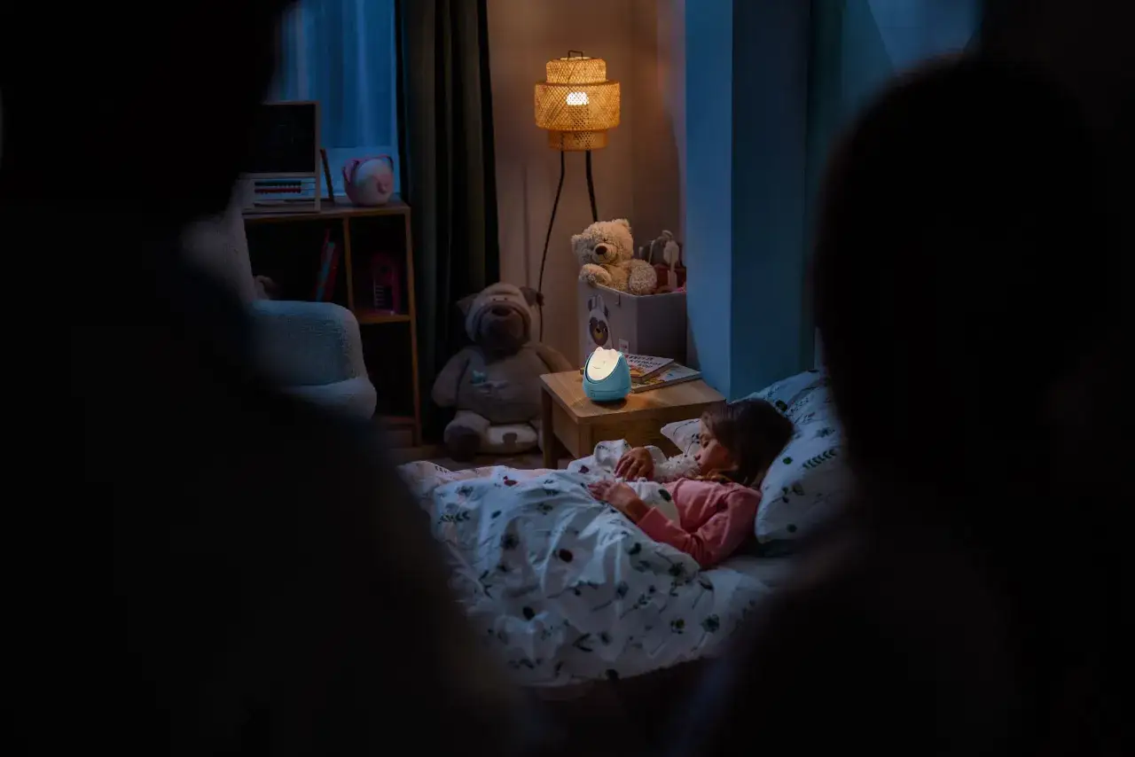 rodzic uspokaja dziecko w ł&oacute;żku nocą