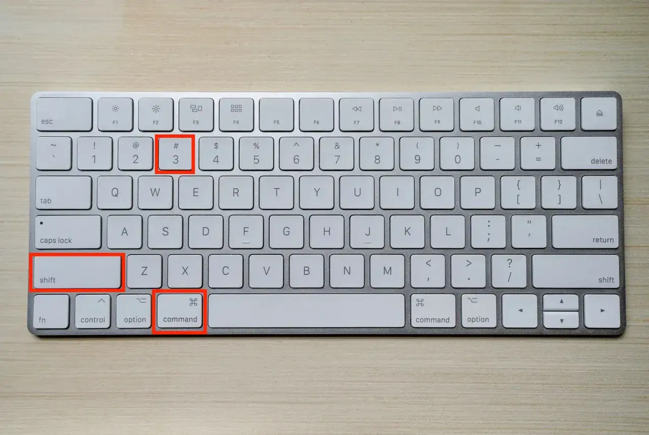 Klawiatura komputerowa z zaznaczonymi klawiszami Shift, Command i cyfrą 3.