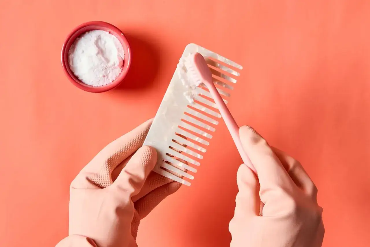 Rękawiczki i szczoteczka do zębów pomagają w czyszczeniu grzebienia. Soda oczyszczona w miseczce to sekret, jak wyczyścić szczotkę do włosów.