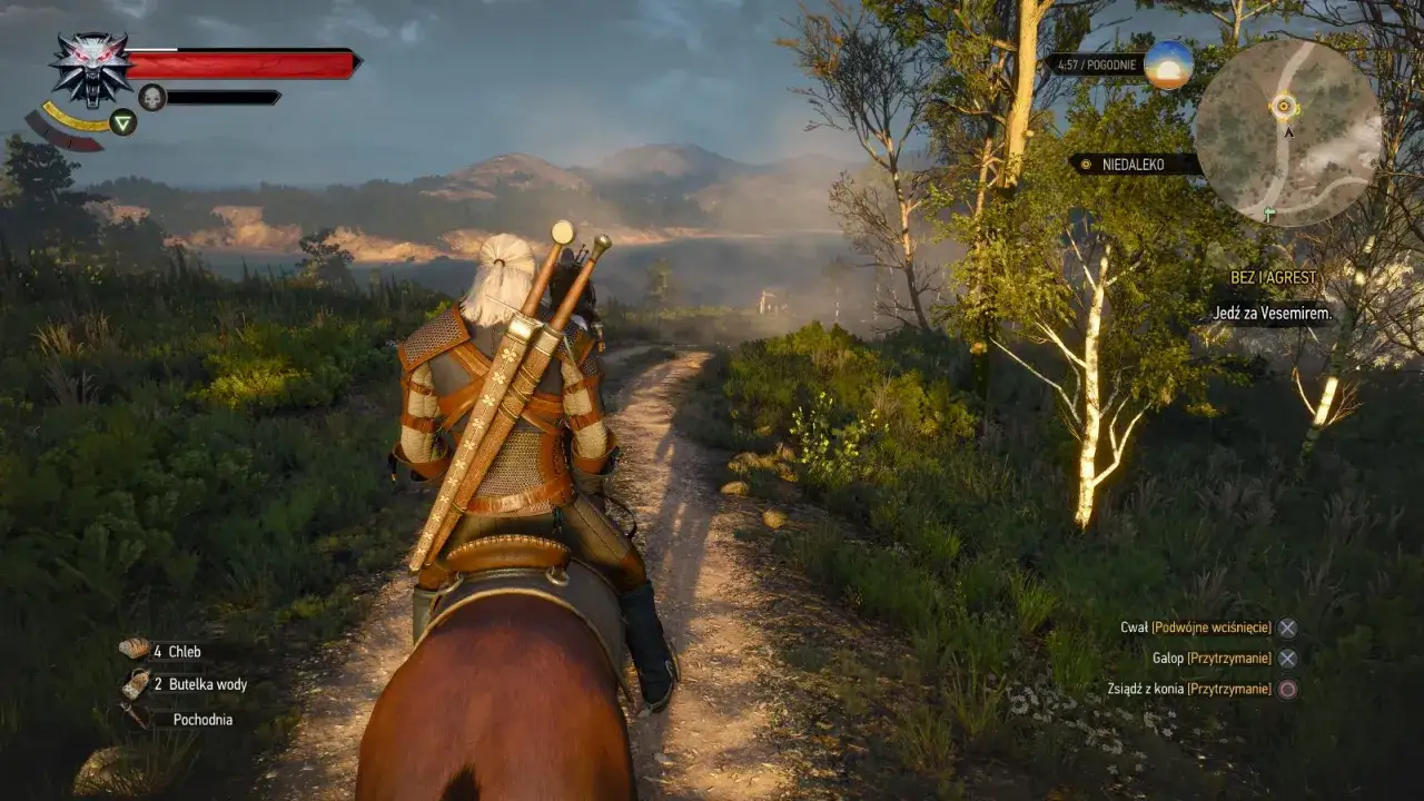 Geralt na koniu w drodze do Vesemira. Wiedzmin 1 remake w pełnej krasie, z pięknymi widokami i interfejsem gry.