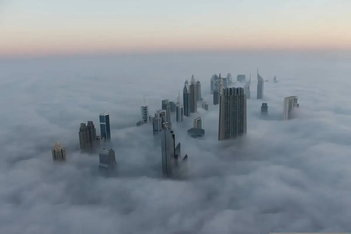 Wolkenkratzer ragen aus dichtem Nebel empor. Ein ungewöhnliches Wetter in Dubai im November, das die Stadt wie eine Fantasiewelt erscheinen lässt.