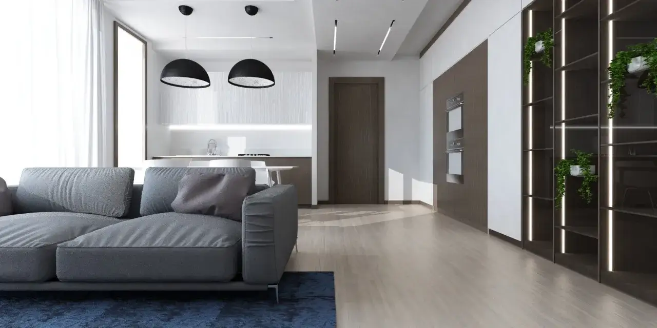 Soggiorno moderno con divano grigio, cucina a vista e scaffalature illuminate. Idee controsoffitto open space per definire gli ambienti.