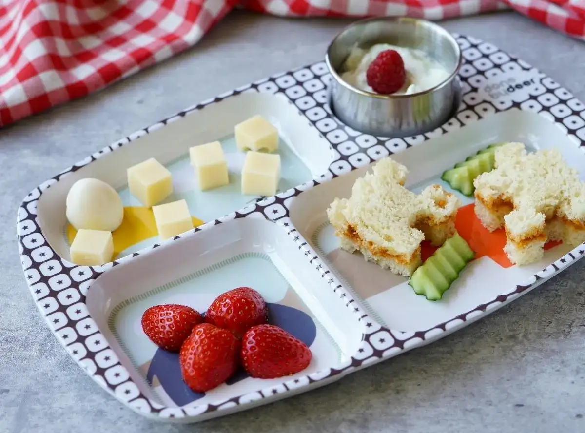 Ein liebevoll zubereiteter Wochenplan Essen Kind 1 Jahr: K&auml;sew&uuml;rfel, Ei, Erdbeeren, Gurke und ein s&uuml;&szlig;es Sandwich.