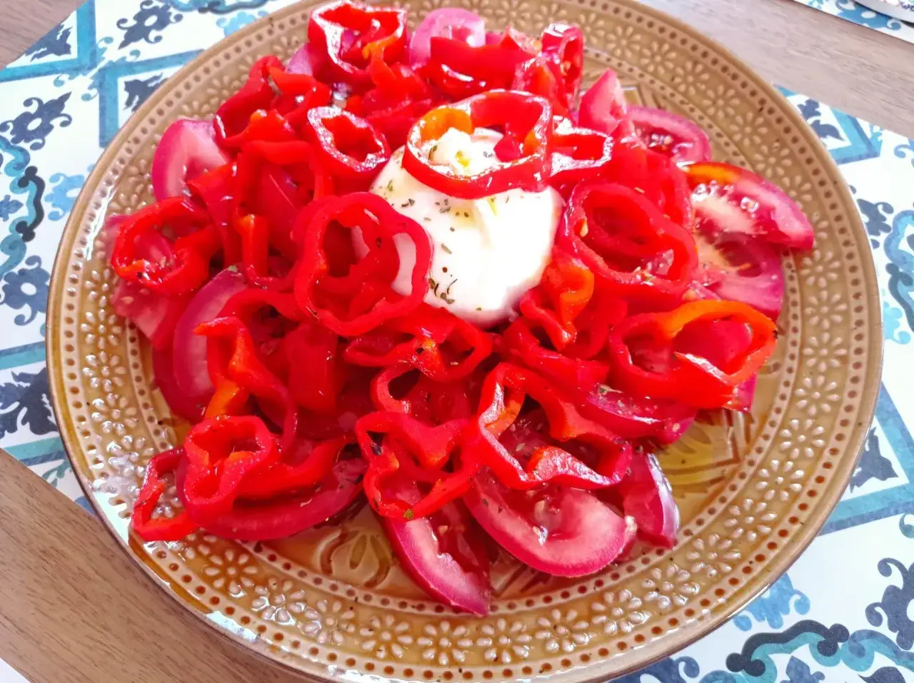 Pyszna burrata z pomidorami i papryką, skropiona oliwą. Idealna na letni obiad.