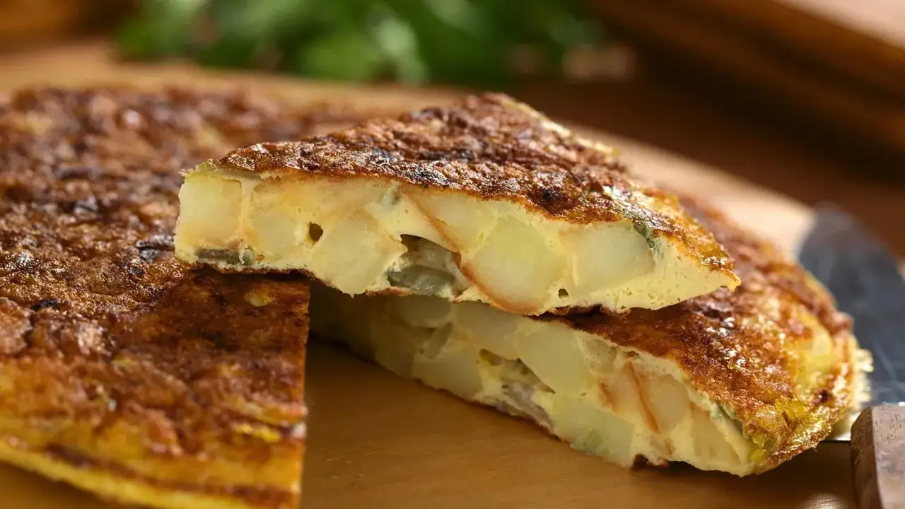 Eine k&ouml;stliche Tortilla de Patatas, mit saftigen Kartoffelst&uuml;cken und goldbrauner Kruste, bereit zum Genie&szlig;en.