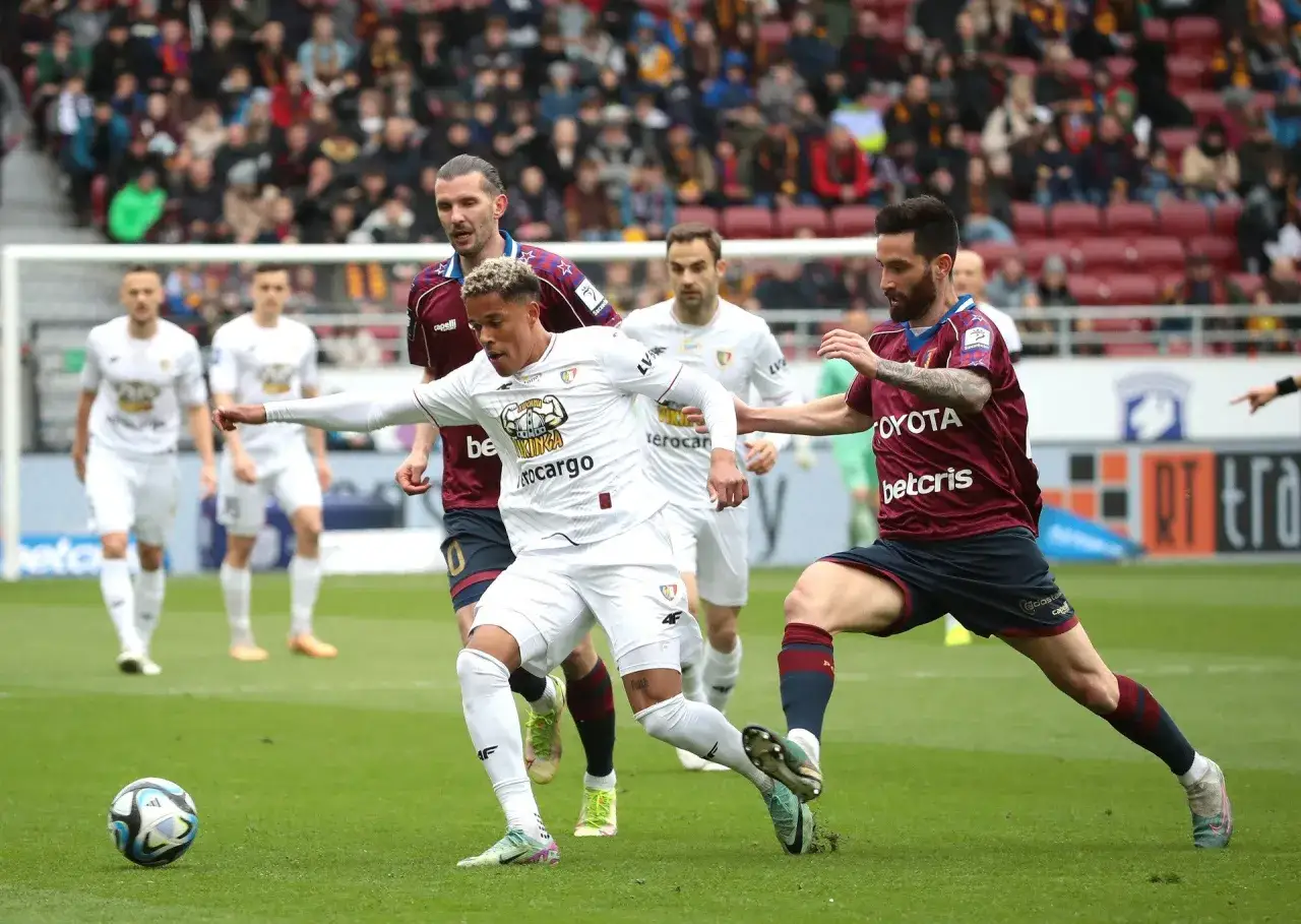 Piast Gliwice kontra Pogoń Szczecin. Piłkarze walczą o piłkę na zielonej murawie, w tle trybuny pełne kibiców.