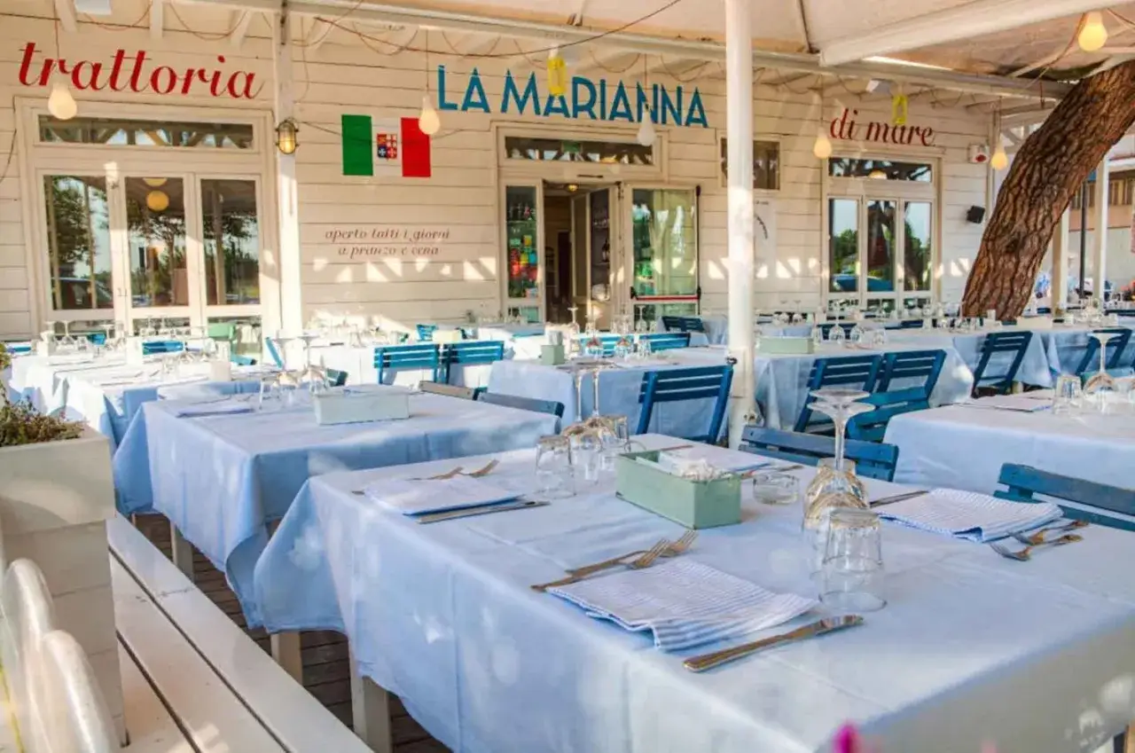 La Marianna, una trattoria a Rimini, pronta per accogliere i clienti con tavoli apparecchiati e vista mare.