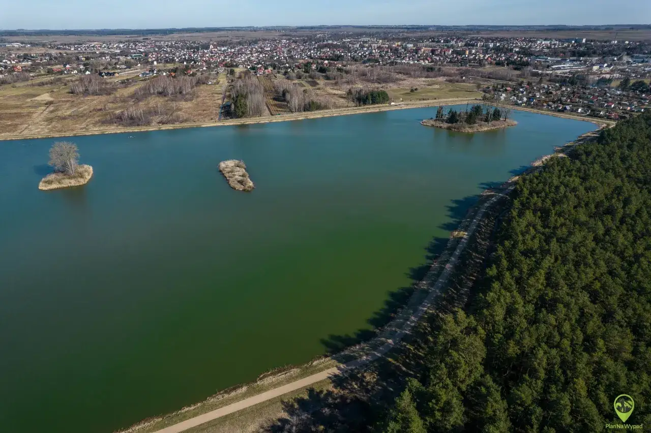 Malownicze jezioro z wysepkami, otoczone lasem i zabudowaniami, to jedne z pięknych jan&oacute;w lubelski atrakcje.