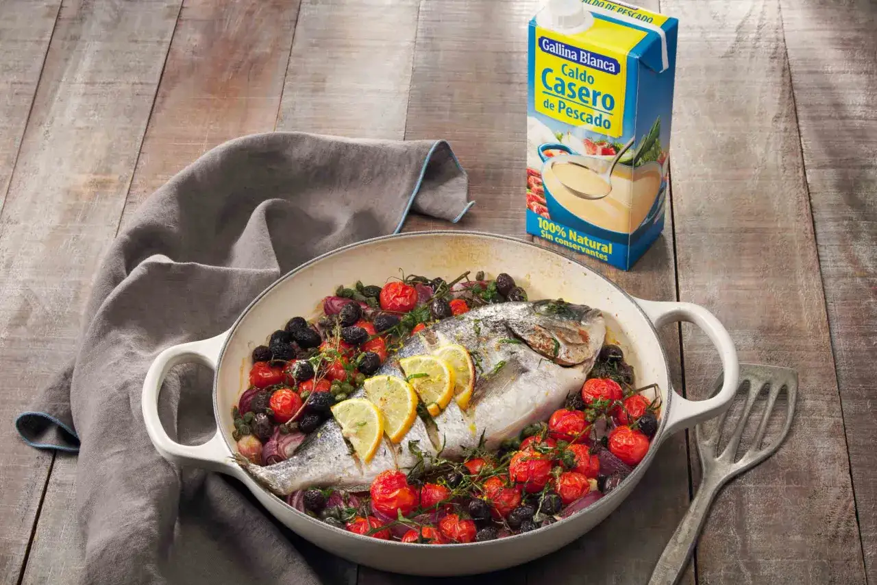 Dorada al horno con tomates, aceitunas y limón, lista para servir. Un plato principal delicioso y saludable.