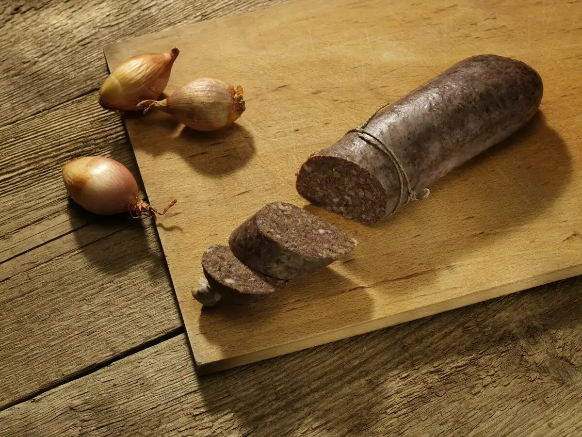 Kaszanka na desce z cebulkami. Z czego jest kaszanka? Z krwi, kaszy i przypraw, idealna do smażenia.