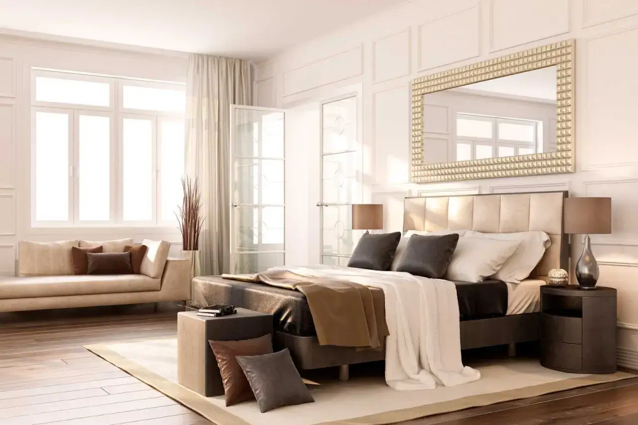Elegancka sypialnia w stylu bauhaus, z dużym łóżkiem, wygodną kanapą i lustrem nad wezgłowiem.