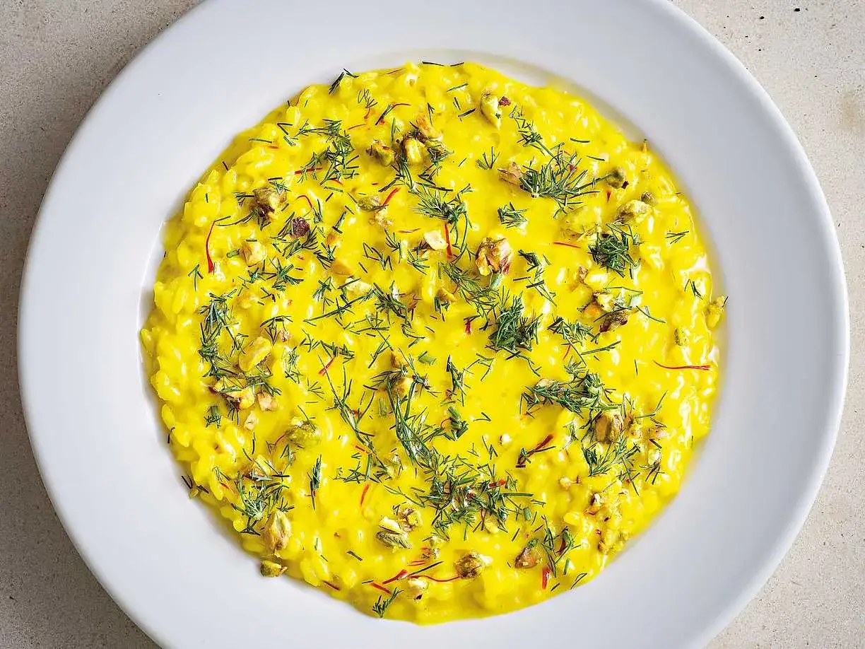 En krämig saffransrisotto med lax, toppad med dill och nötter. En festlig rätt som passar perfekt för speciella tillfällen.