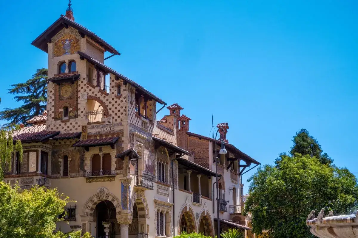 Edificio Liberty nel quartiere Copped&egrave;, con decorazioni floreali e mosaici, sotto un cielo azzurro.