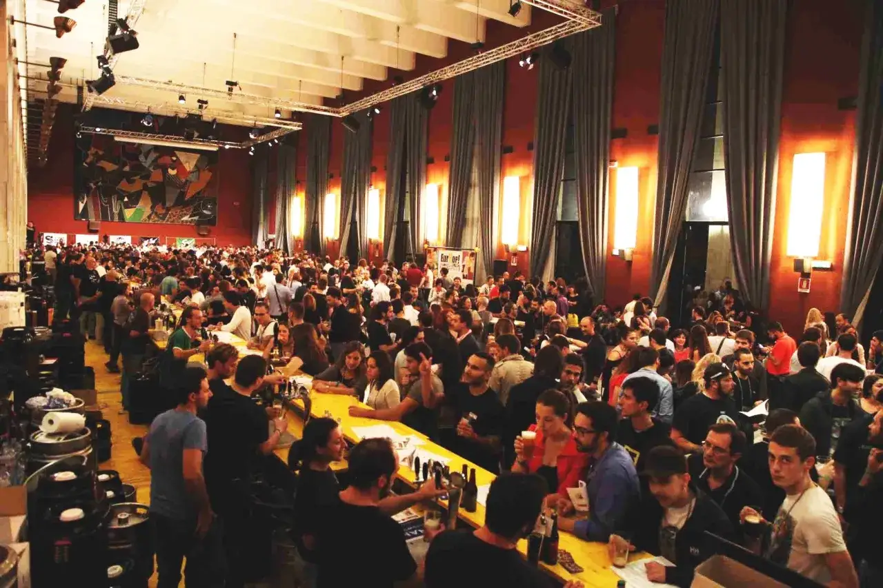 Folla festante a un evento, con un cartello che recita 