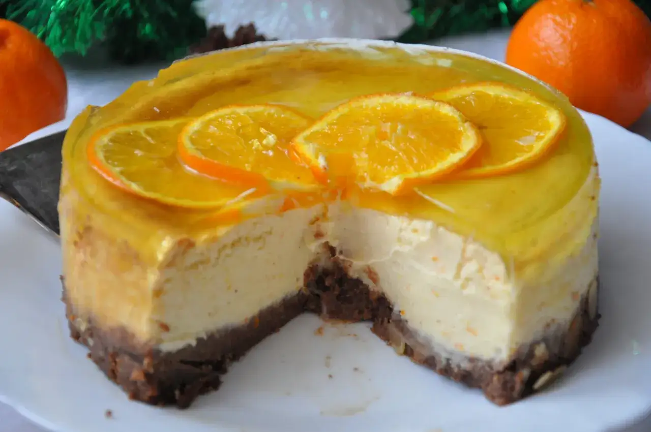 Pyszny sernik pomarańczowy z mascarpone, udekorowany plasterkami pomarańczy i galaretką. Idealny na święta!