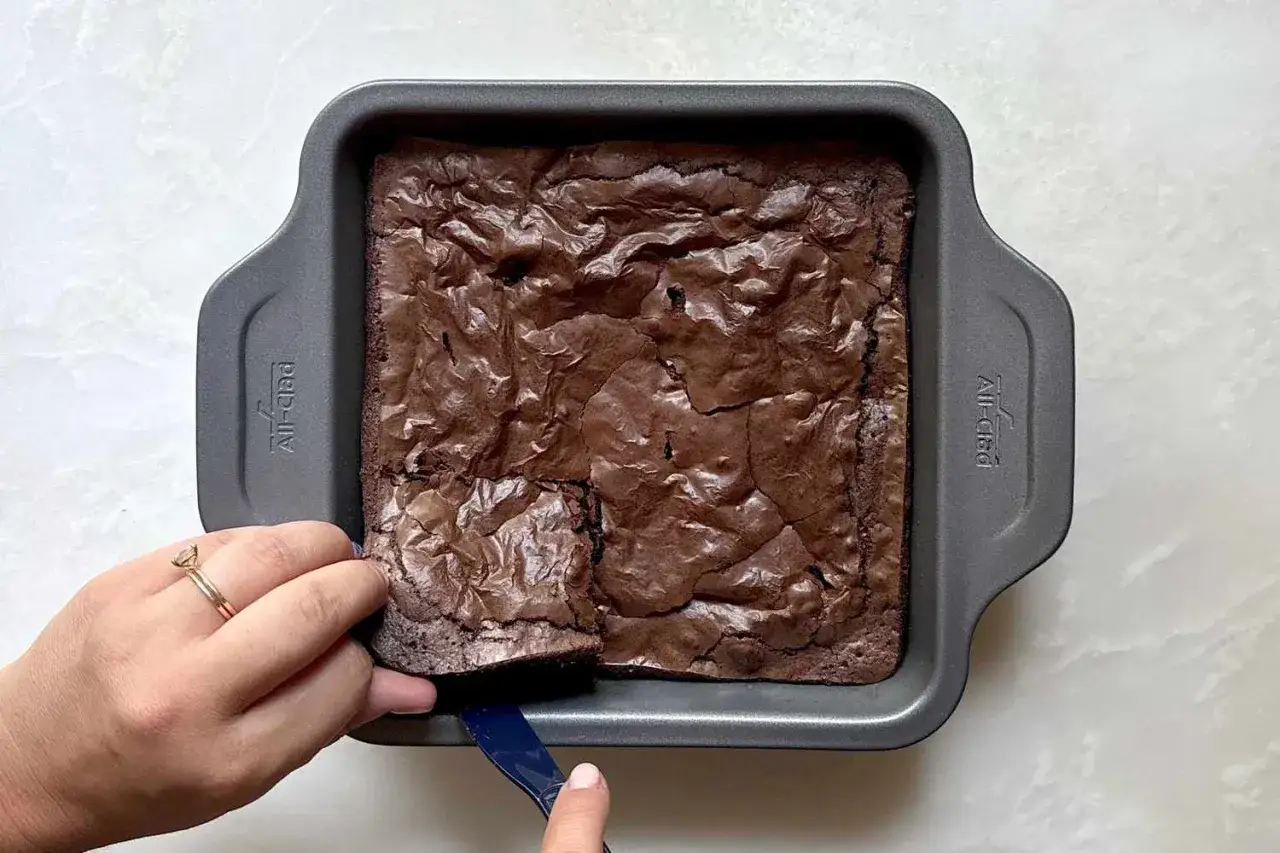 Ein frisch gebackener Brownie im Blech, bereit zum Anschneiden. Dieses Brownie Rezept ist ein Traum!