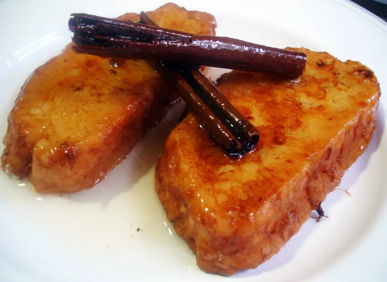 Dos deliciosas torrijas doradas, bañadas en almíbar y coronadas con canela. ¡La mejor receta de torrijas para disfrutar!