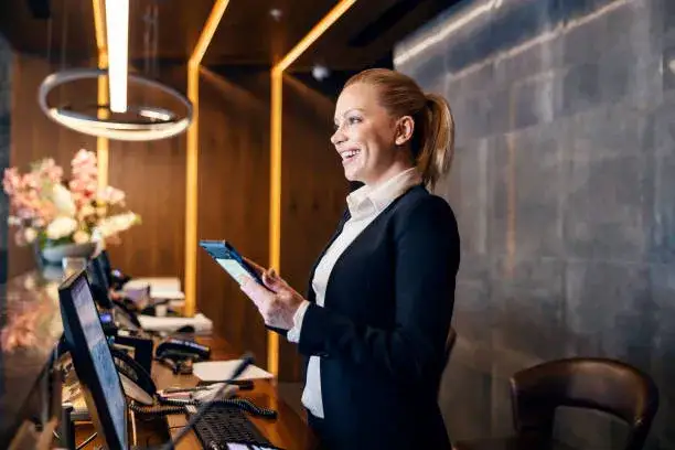 recepcja hotelowa z uśmiechniętym pracownikiem